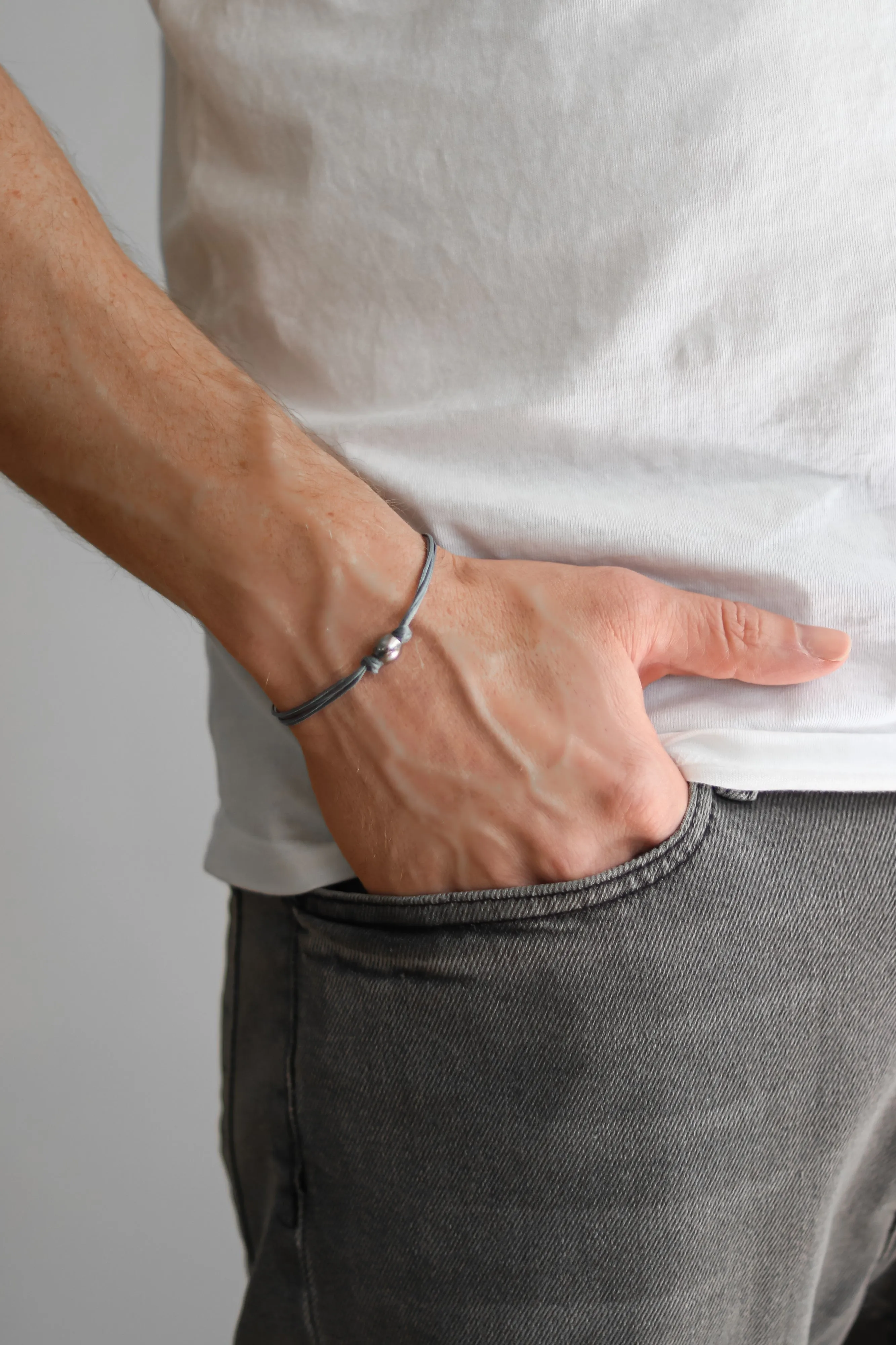 Men's bracelet with silver bead charm and a gray cord