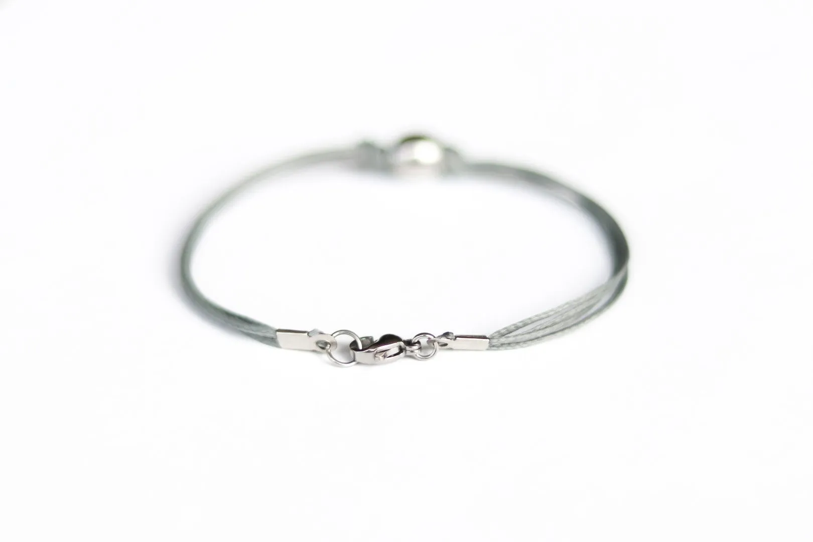 Men's bracelet with silver bead charm and a gray cord